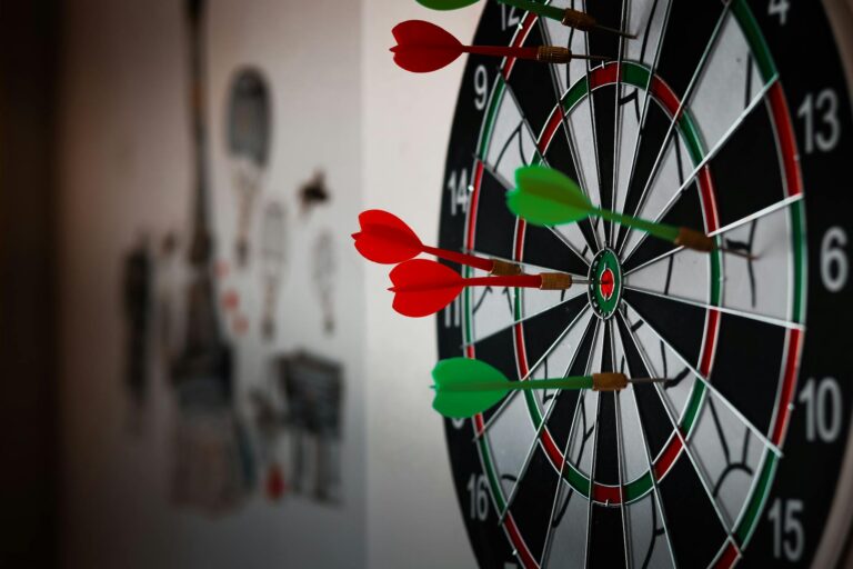 Darts in Zeiten der Energiekrise Wie Spieler und Fans jetzt durchhalten Dartspieler trainieren energieeffizient in gedämpft beleuchteter Halle während Energiekrise