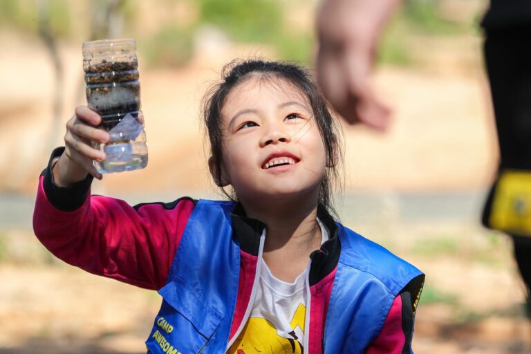 Outdoor Wasserfilter in der Hand eines Wanderers vor Flusslauf